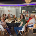 A photo of a group of women seated around a round table in a restaurant.